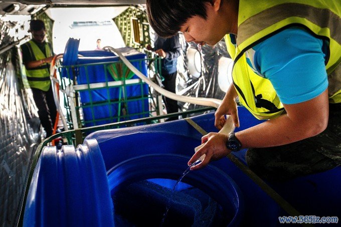 Các nhân viên cơ quan tạo mưa hoàng gia chuẩn bị đá và nước trong thùng chứa máy bay. Ảnh: AFP