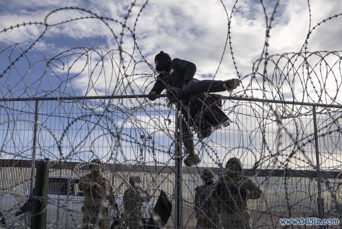 Người nhập cư trèo qua hàng rào từ Ciudad Juarez, Mexico vào El Paso, bang Texas, Mỹ ngày 2/4/2024. Ảnh: AFP